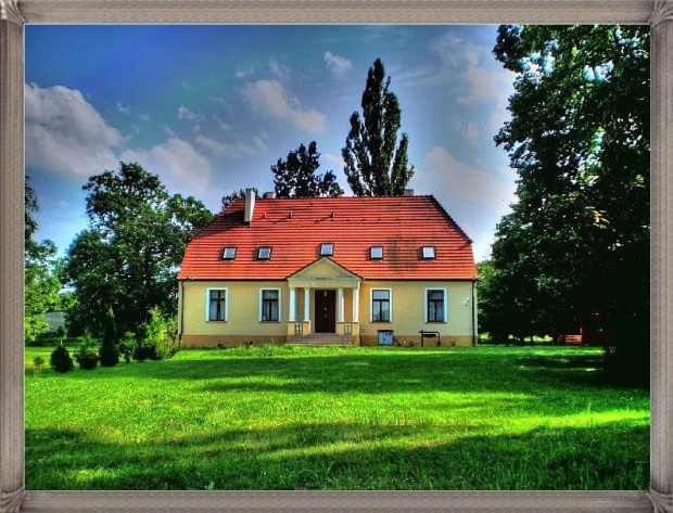 Dwór w Gogolewie ( powiat śremski ) z końca XVIII w., z dachem naczółkowym i nowszym gankiem .