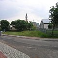 Centrum wsi Pustków. w głębi kościół pw. Św. Józefa Rzemieślnika. Na niewielkim wzniesieniu stał tutaj dwór, dzisiaj w tym miejscu mały domek.