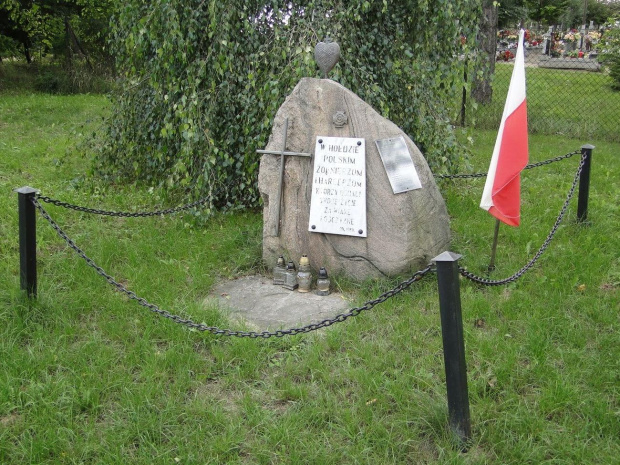 Obok kościoła , przy wejściu na cmentarz znajduje się głaz narzutowy z tablicą z 1989 roku ; poświęcona jest poległym żołnierzom i harcerzom .